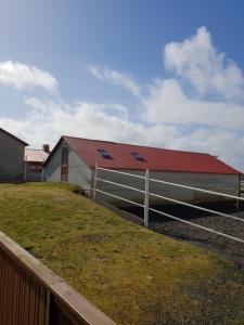 a barn with a red roof and a fence at The Coffee House in Selfoss