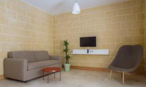 a living room with a couch and a tv on a wall at Mellieha Holiday Centre in Mellieħa