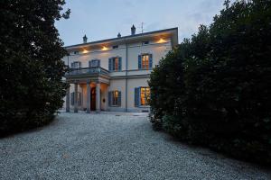 a large white house with lights on it at Villa Platamone in Como