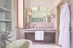 a bathroom with a tub and a sink and a mirror at Villa Platamone in Como +45 photos