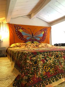 a bedroom with a bed with a butterfly on the wall at La casetta dei Mosaici in Capraia