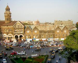 a large building with a lot of cars in a parking lot at Aman Hotel near CST in Mumbai