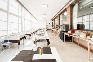 a dining room with tables and chairs and windows at Hotel Catullo in San Martino Buon Albergo