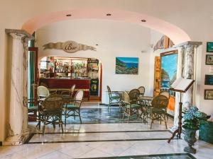 un restaurante con mesas y sillas y un bar en Hotel Bonadies, en Ravello