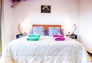 una camera da letto con un letto bianco con cuscini blu e bianchi di Independencia Square Viewpoint a Mendoza