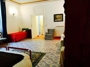ein Wohnzimmer mit einem roten Sofa und einem roten Stuhl in der Unterkunft Casa del Baronello in Palermo