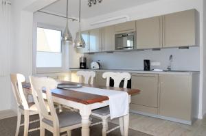 une cuisine avec une table en bois et des armoires blanches dans l'établissement Villa Herbstwind in Binz, à Binz