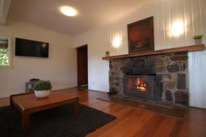 sala de estar con chimenea de piedra y mesa en Sunny Corner Lake Eildon, en Eildon