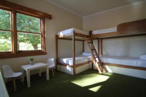 イールドンにあるSunny Corner Lake Eildonの二段ベッド2台、テーブル、窓が備わる客室です。