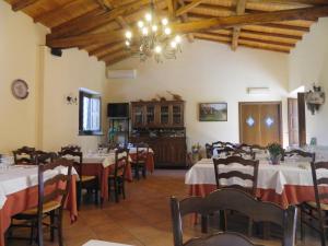 a dining room with tables and chairs and a chandelier at Agriturismo La Grevillea in Riposto