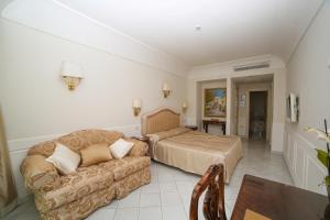 a living room with a bed and a couch at Hotel Villa Fraulo in Ravello