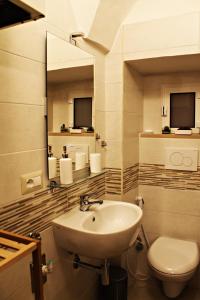 a bathroom with a sink and a toilet and a mirror at B&B La Campanella in Putignano