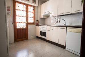uma cozinha com armários brancos, um lavatório e uma janela em VUT Plaza de la Fruta em Ávila