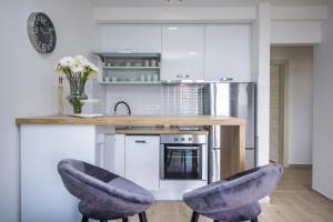 a kitchen with two purple chairs and a counter at Apartmani i studio Big Hill in Makarska