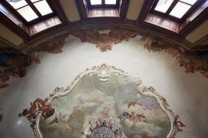 a ceiling with a painting on a wall with windows at Villa Platamone in Como