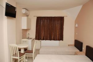 Pokój z 2 łóżkami i stołem oraz kuchnią w obiekcie Prenoćište Kovač w mieście Vranje