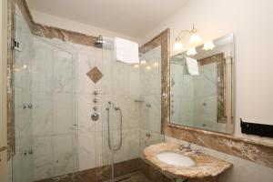 a bathroom with a sink and a shower with a mirror at Hotel Villa Fraulo in Ravello