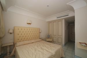 a bedroom with a large bed and a chair at Hotel Villa Fraulo in Ravello