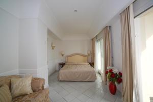 a bedroom with a bed and a couch in a room at Hotel Villa Fraulo in Ravello