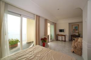 a bedroom with a bed and a living room at Hotel Villa Fraulo in Ravello