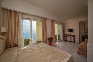 a bedroom with a large bed and a balcony at Hotel Villa Fraulo in Ravello