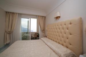a bedroom with a large bed with a large headboard at Hotel Villa Fraulo in Ravello