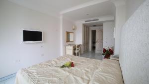 a white room with a bed and a television at Hotel Villa Fraulo in Ravello