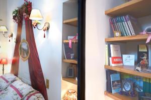ミタンヴィルにあるMaison d'Hotes à l'Ombre Bleueの本棚の横に鏡付きのベッドルーム