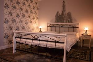 a bedroom with a white bed with flowers on the wall at Apartmány Kord in Lednice