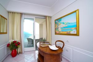 a room with a desk with a phone and a window at Hotel Villa Fraulo in Ravello