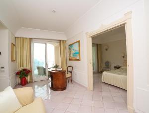 a hotel room with a bed and a table at Hotel Villa Fraulo in Ravello