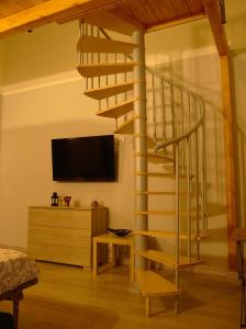 uma sala de estar com uma escada em espiral e uma televisão em Katane Apartment em Catânia