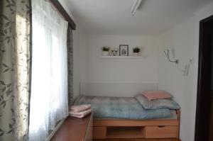 a small bed in a room with a window at Garden house in Bratislava