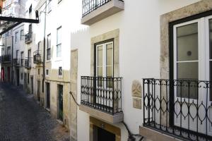 リスボンにあるCasa Ginja - Checkinhomeの白い建物とバルコニーのある路地