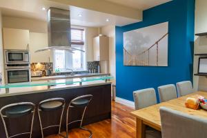a kitchen with a dining table and a bridge painting on the wall at Apartment No 1 - The Old Red King Pub, Whitefield, Manchester in Manchester