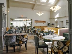 a dining room with tables and chairs and people in the background at Clonakilty Park Hotel in Clonakilty