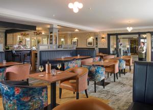um restaurante com mesas e cadeiras de madeira e um bar em Clonakilty Park Hotel em Clonakilty