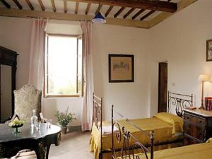 a bedroom with two beds and a table and a window at Castello di Grotti in Corsano