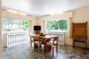 a dining room with a table and two windows at Haus mit Garten über der Bucht von Cannes in Vallauris