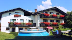 a house with a pool in front of a house at Garden Apartments Janša in Radovljica