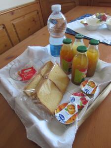 einen Teller mit Speisen mit Sandwiches und Flaschen Saft in der Unterkunft Casa Giuliano in Pincara