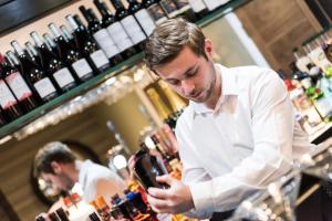 a man standing at a bar looking at his cell phone at Belmont Llandudno in Llandudno