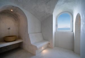 a white room with a window and a bench at Bellevue Syrene in Sorrento