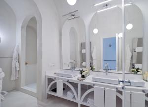 a bathroom with two sinks and a large mirror at Bellevue Syrene in Sorrento