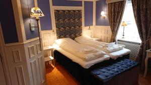 ein kleines Bett in einem Zimmer mit Fenster in der Unterkunft Garvaregården Hotel , B&B och Café in Askersund