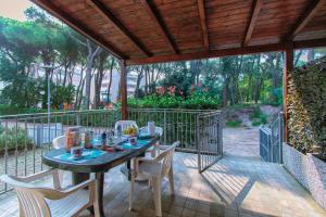 a patio with a table and chairs on a deck at Villa Sofia in Rosolina Mare