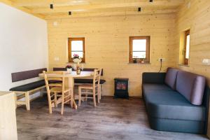 a living room with a couch and a table and chairs at Holiday house Jereka -Bohinj in Bohinj