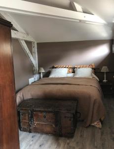 a bedroom with a bed with a wooden chest at the end at Le Clos des Moulins 2 rue des cotes de l'Héry in Hautvillers +5 photos