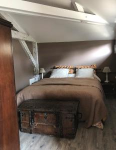 a bedroom with a bed with a wooden chest at the end at Le Clos des Moulins in Hautvillers