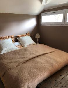 a bedroom with a large bed with a window at Le Clos des Moulins in Hautvillers